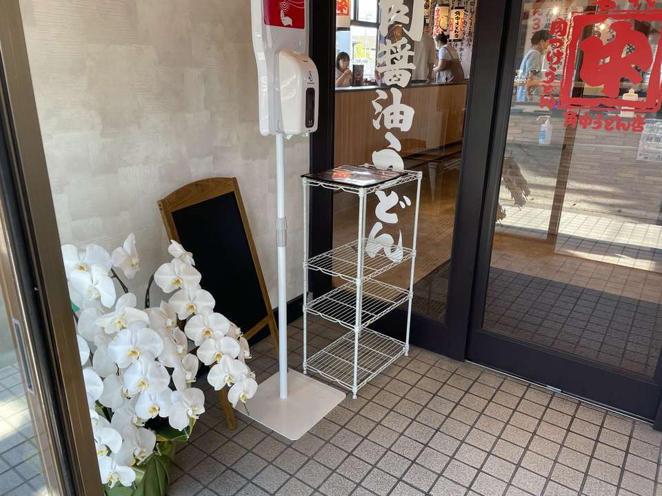 角中うどん店黒埼店の入り口に飾られたお祝いの白い胡蝶蘭